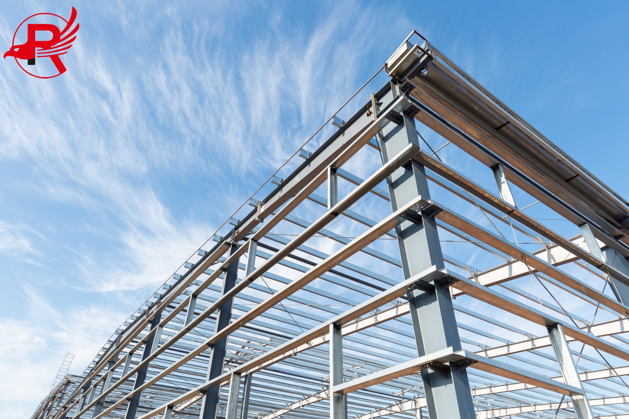 steel frame workshop is under construction against a blue sky